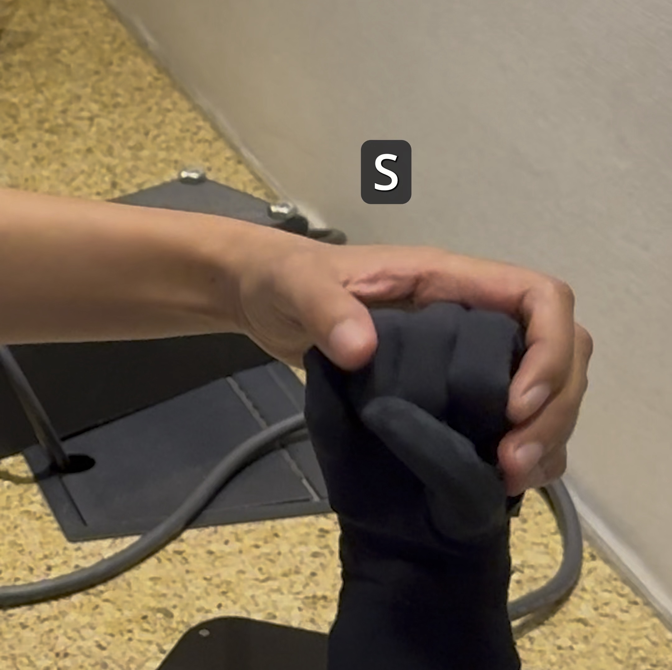 Video: Haben feeling a black robotic hand that is signing the letter "S"