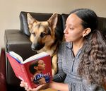I'm sitting on the floor holding open a print book for Mylo. The cover has a portrait of me in profile with the title, “Haben: The Deafblind Woman Who Conquered Harvard Law.” Beside me, relaxing on a black sofa, a German Shepherd dog with the pointiest ears looks down at the book with complete fascination.