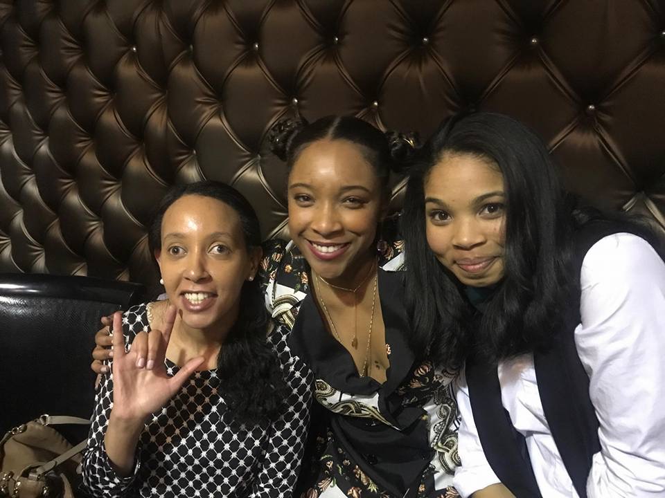 Haben Girma, Treshelle Edmond, and Carmen LoBue are smiling and leaning in for the camera. Haben holds up the sign for “I Love You” in American Sign Language. Photo by Treshelle Edmond.