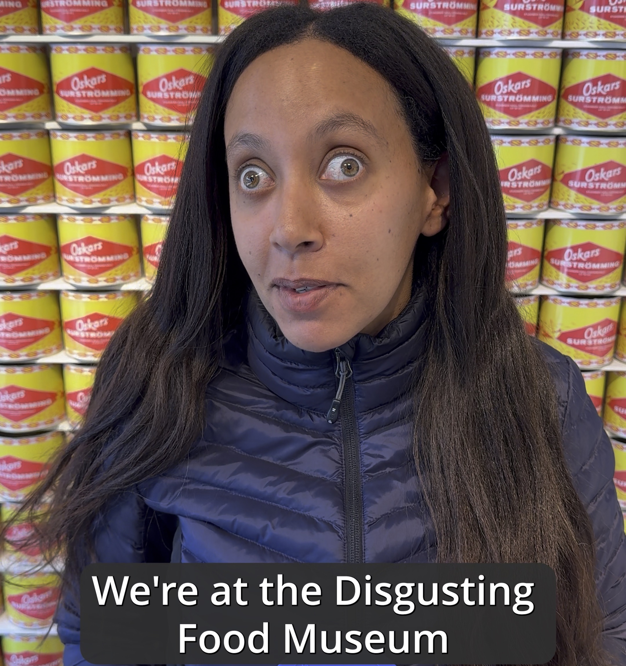Haben standing in front of a wall of Surströmming in the Disgusting Food Museum in Malmö, Sweden